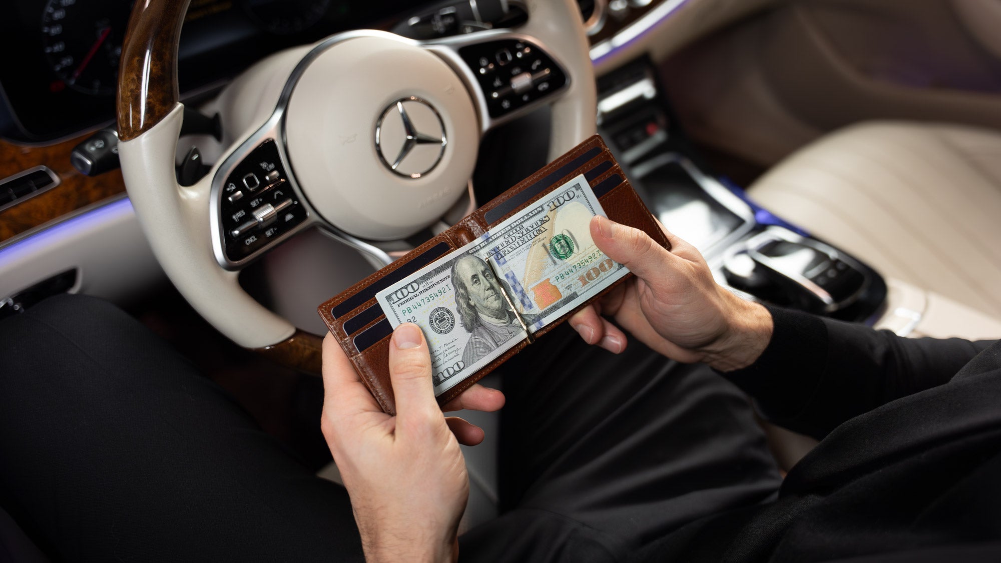 A lifestyle shot of the Von Baer leather money clip, a compact men's wallet in solid brown, highlighting its sleek and premium design.