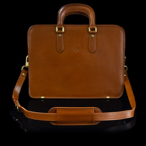 A tan Von Baer leather shoulder bag strap is shown on a leather bag.