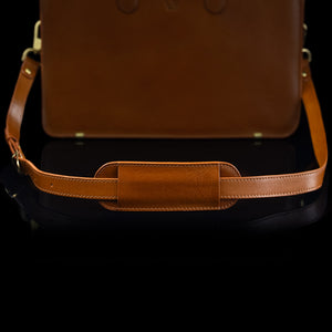 A tan Von Baer leather shoulder bag strap is shown on a leather bag.