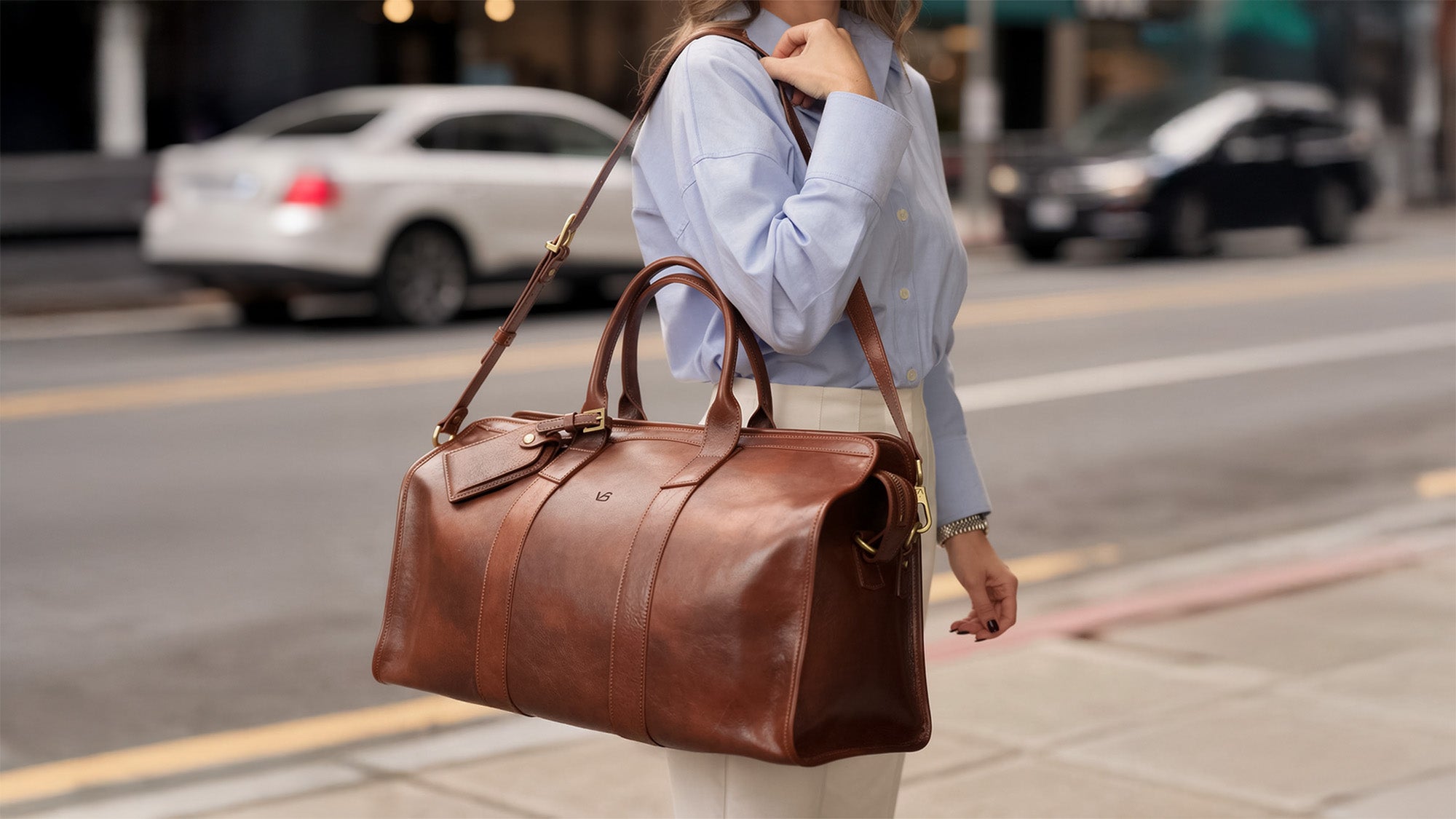 Von Baer leather weekender bag on a female model on the street, stylish travel bag for weekend trips.