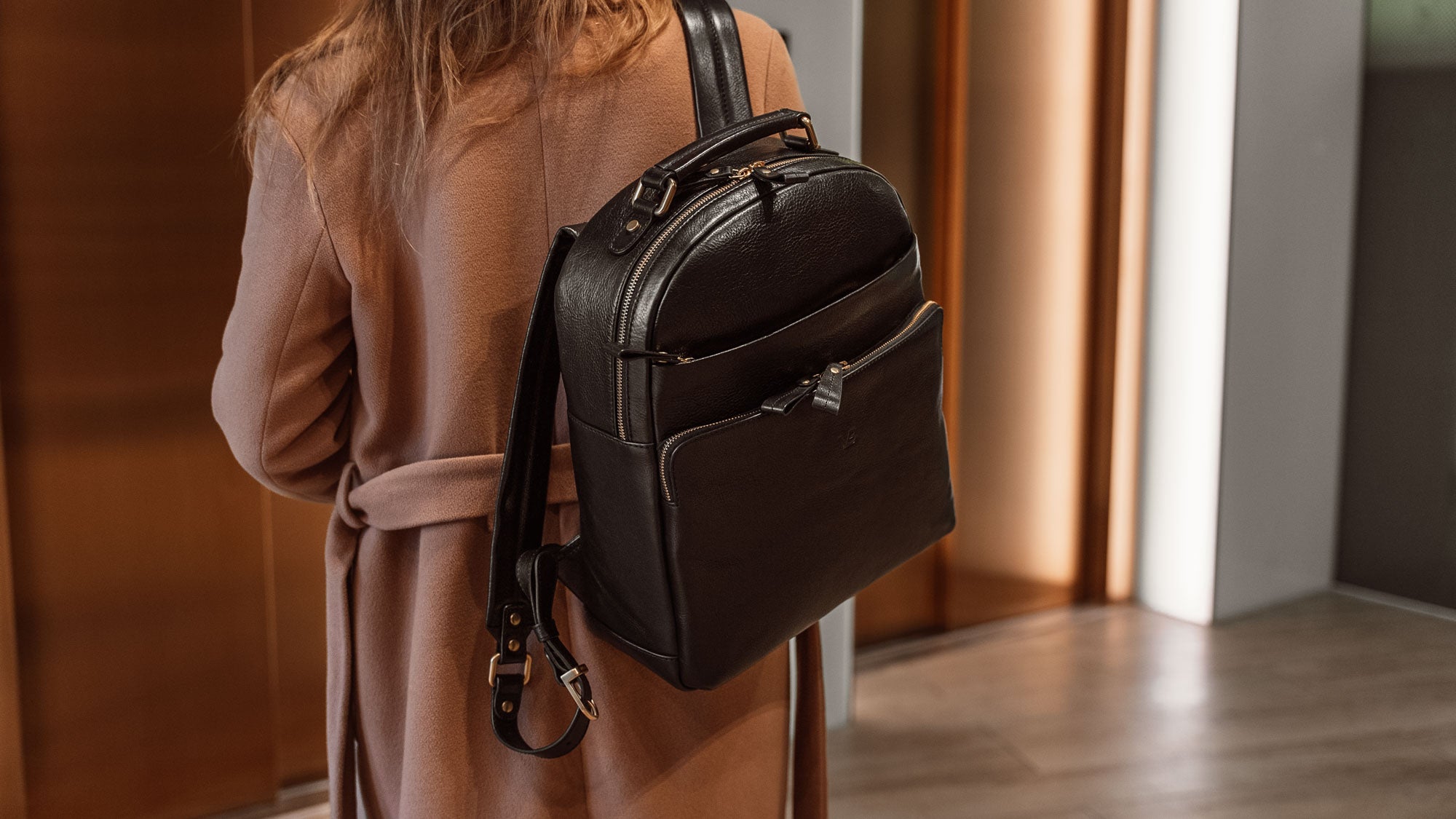 Von Baer Liberty stylish women's full-grain leather backpack black on a beautiful woman in a beige coat