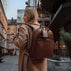 Von Baer Liberty stylish women's full-grain leather backpack brown on a beautiful woman in a beige coat on the street
