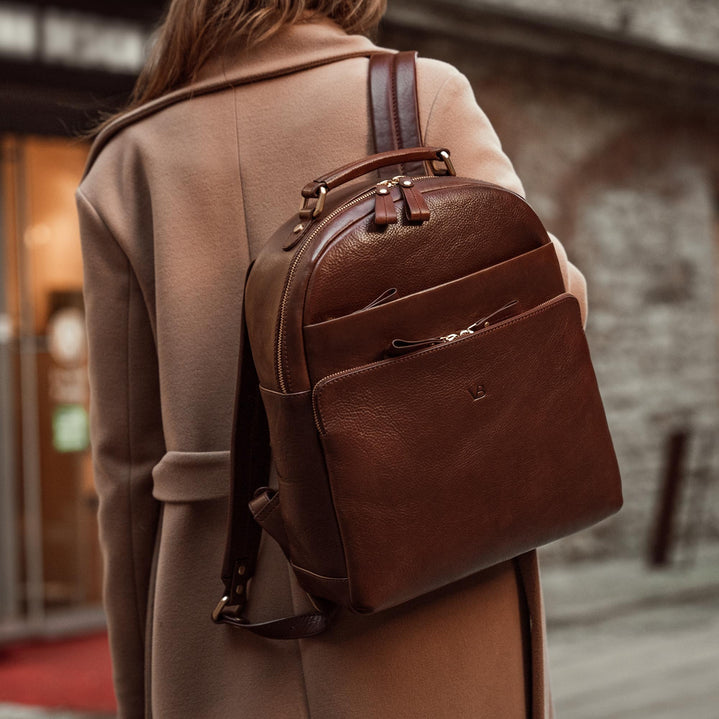 Von Baer Liberty stylish women's full-grain leather backpack in brown, worn by a woman in a beige coat