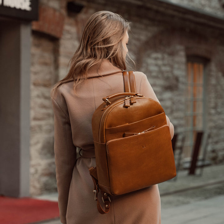 Von Baer Liberty stylish women's full-grain leather backpack in tan, worn by a woman in a beige coat