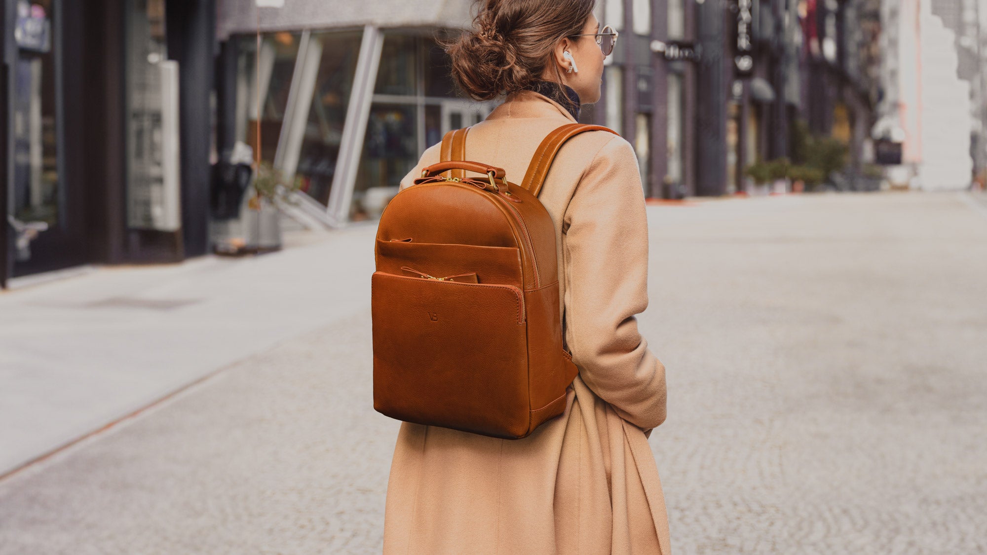 Von Baer Liberty women's stylish Italian leather backpack in tan, worn by a female model, showcasing a chic and practical lifestyle look.