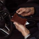 von baer luxury grant leather card case wallet solid brown in the hands of businessman
