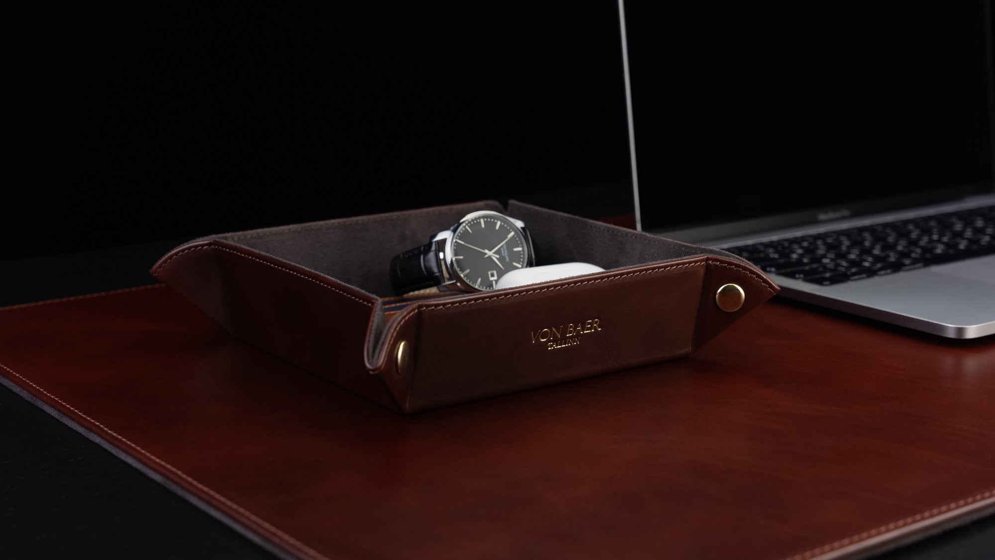 Von Baer Majestic luxury Italian leather tray desk organizer, catch-all in brown, placed on a leather desk pad and filled with items, showcased in a slider.