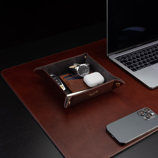 Von Baer Majestic luxury Italian leather tray desk organizer, catch-all in brown, placed on a leather desk pad and filled with accessories.