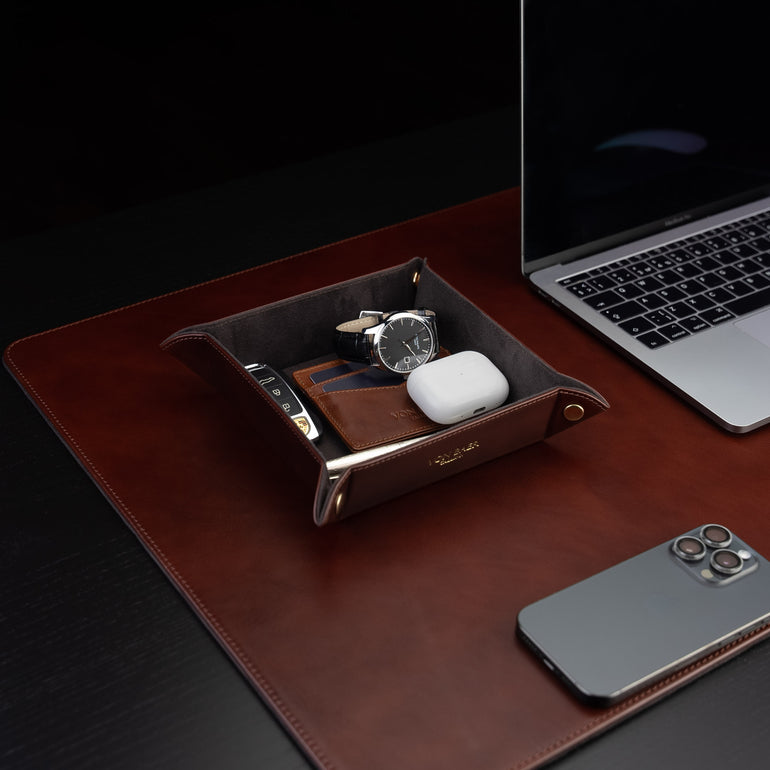 Von Baer Majestic luxury Italian leather tray desk organizer, catch-all in brown, placed on a leather desk pad and filled with accessories.