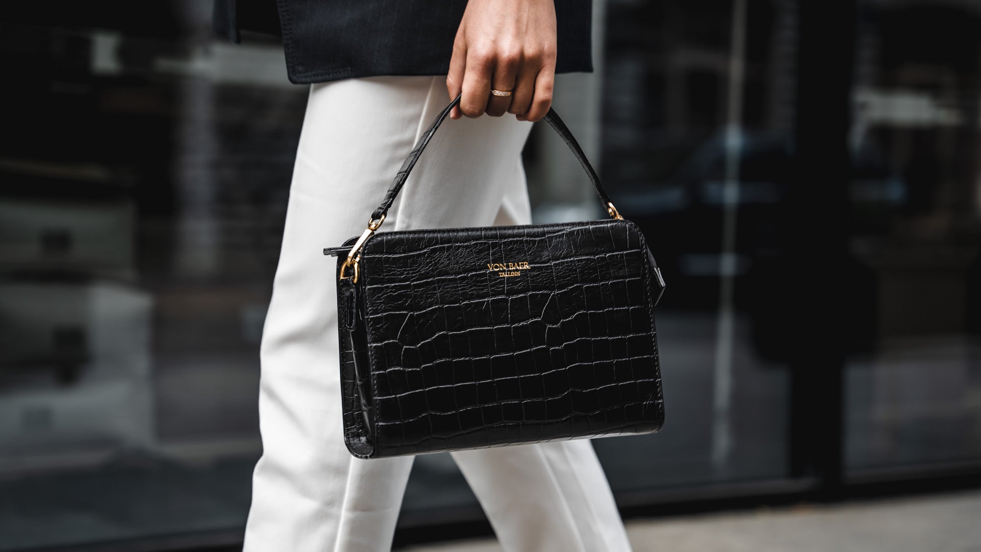 Von Baer Model 1 small luxury leather purse in croco style close-up in hands lifestyle slider