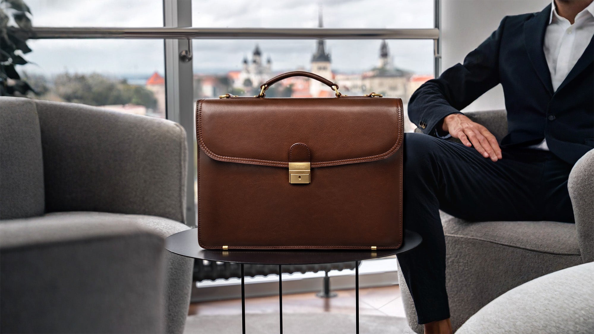 Von Baer No.1 luxury men’s leather briefcase for laptop and documents on a city office background, business bag for professional work.