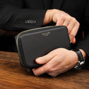 Von Baer origin luxury RFID men’s leather wallet in black held by a male model in a cafe, premium wallet for cards and cash.