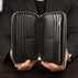 Von Baer origin luxury RFID men’s leather wallet in black held by a male model showing interior pockets for cards and cash.