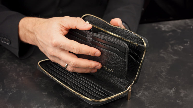 Von Baer origin luxury RFID men’s leather wallet in black with detachable card holder, held by a male model.