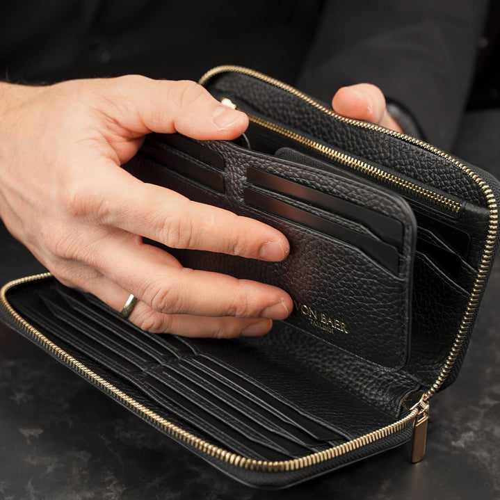 Von Baer origin luxury RFID men’s leather wallet in black held by a male model with detachable card holder, premium wallet for cards and cash.