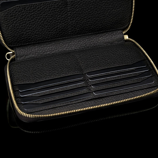 Luxury men’s leather wallet with RFID protection, large design with card slots filled with cards, bottom section visible.