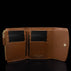 Von Baer Reverie compact cognac pebbled leather wallet for women, open to showcase card slots, interior pockets, and gold-tone snap closure against a reflective black background