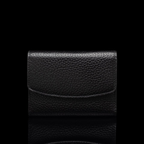 Von Baer Reverie small black pebbled leather wallet for women with an envelope-style flap, shown centered in a front view against a solid black background with a subtle reflection.