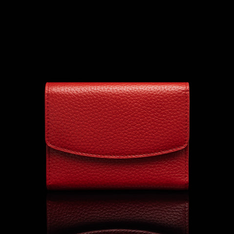 Von Baer Reverie small deep red full-grain pebbled leather wallet for women with a curved envelope-style flap, shown centered in a front view against a solid black background with a subtle reflection.