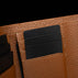 Von Baer Reverie luxury cognac pebbled compact leather wallet for women, shown in close-up with black cards inserted into the interior card slots against a dark background