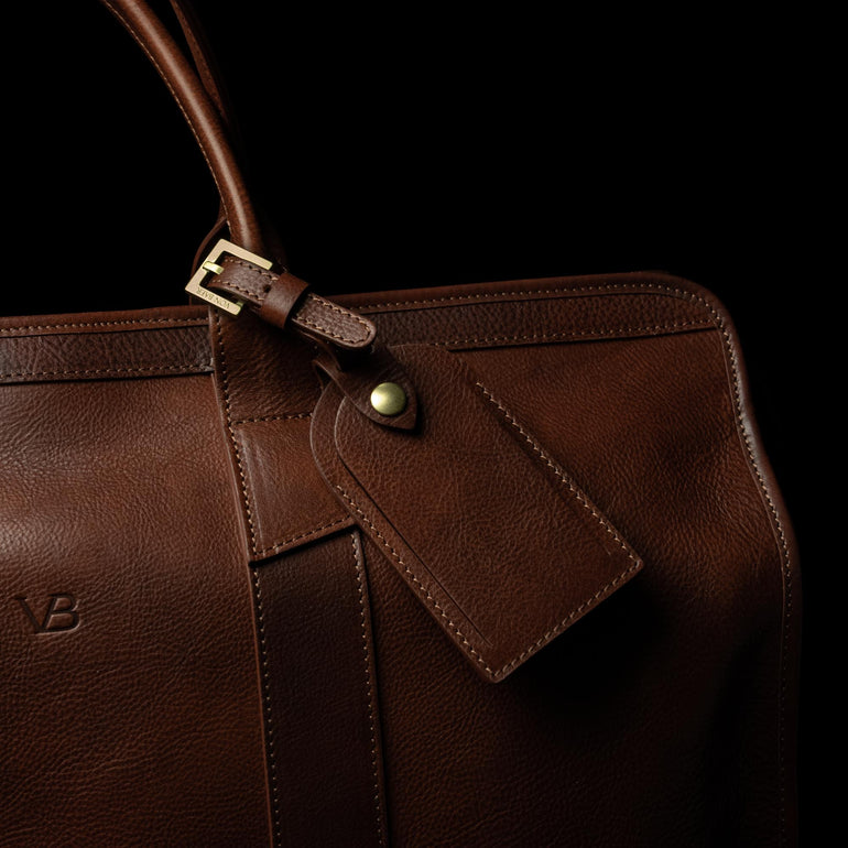 classic leather luggage tag solid brown back view attached to a travel bag